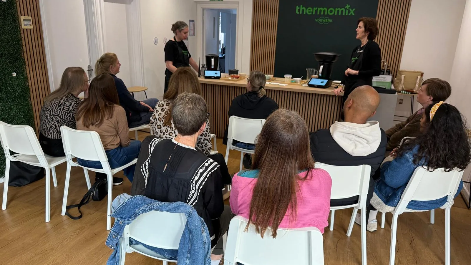 Maria cooking on a Thermomix TM7 at a customer's kitchen island while guests watch.